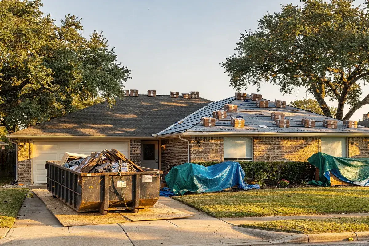 A tidy roof replacement jobsite at a suburban Texas brick home